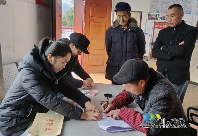 钟丽（左一）在泸县得胜镇上顶山村为部分社员发放工资.png