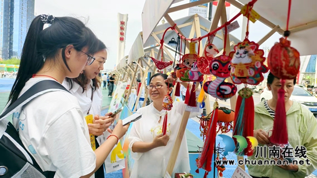 图1：杨丽平（左3）给游客介绍香囊.jpg