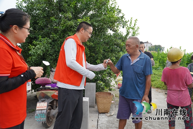 “柠”聚爱心 共“套”丰收|泸县嘉明镇双河口村举行“公益助农 柠檬套袋”活动(图1) 发放解暑的物品(刘孝春摄).jpg