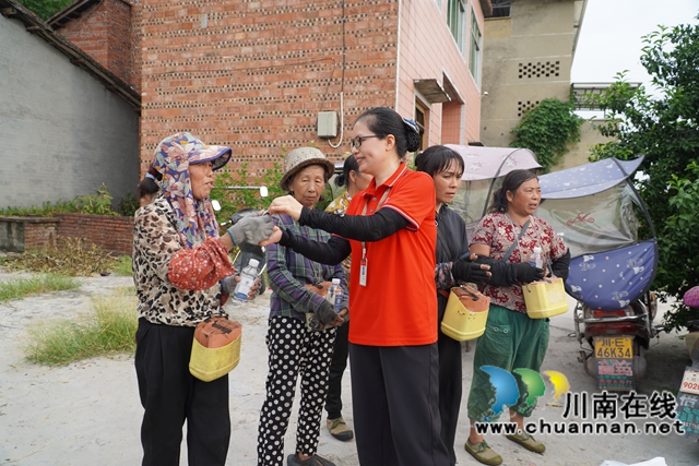 “柠”聚爱心 共“套”丰收|泸县嘉明镇双河口村举行“公益助农 柠檬套袋”活动(图3) 发放水、藿香正气液等解暑物品(刘孝春摄).jpg